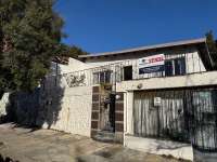 Lote centrico en venta para desarrollo con dos viviendas para renta.
